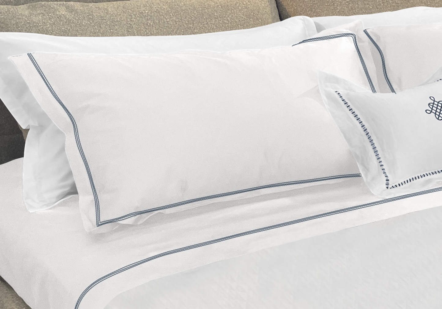 Narragansett White Pillow Sham with a triple contrasting stitch in Deep Sea. It is shown with our Daily Basics 300tc Egyptian Cotton Sateen Sleeping Sham in White. 