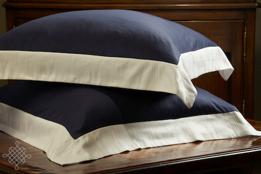 Photo by WAB Studio of 2 stacked Navy Soleil Sateen Eurio Shams with White Soleil Jacquard  BOrders on four sides.  300tc fine egyptian cotton sateen.  Woven and Made in italy and part of Kearsley's Nantuacket Collection.  A Kearsley Daily Essentials..  Oxford Cusihion Covers.